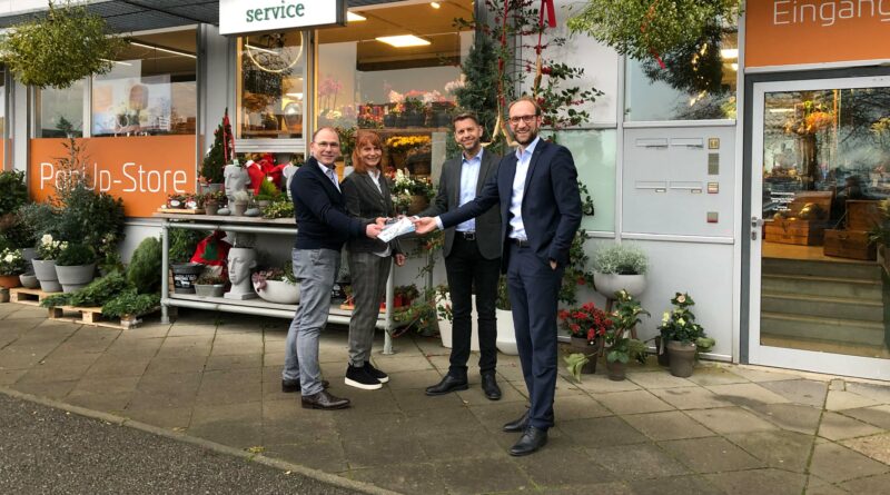 Klarhöfer Blumen feiert 60-jähriges Jubiläum, Frank und Gabi Klarhöfer erhalten vor ihrem Geschäft Glückwünsche von Oberbürgermeister Dennis Weilmann und WMG-Geschäftsführer Jens Hofschröer